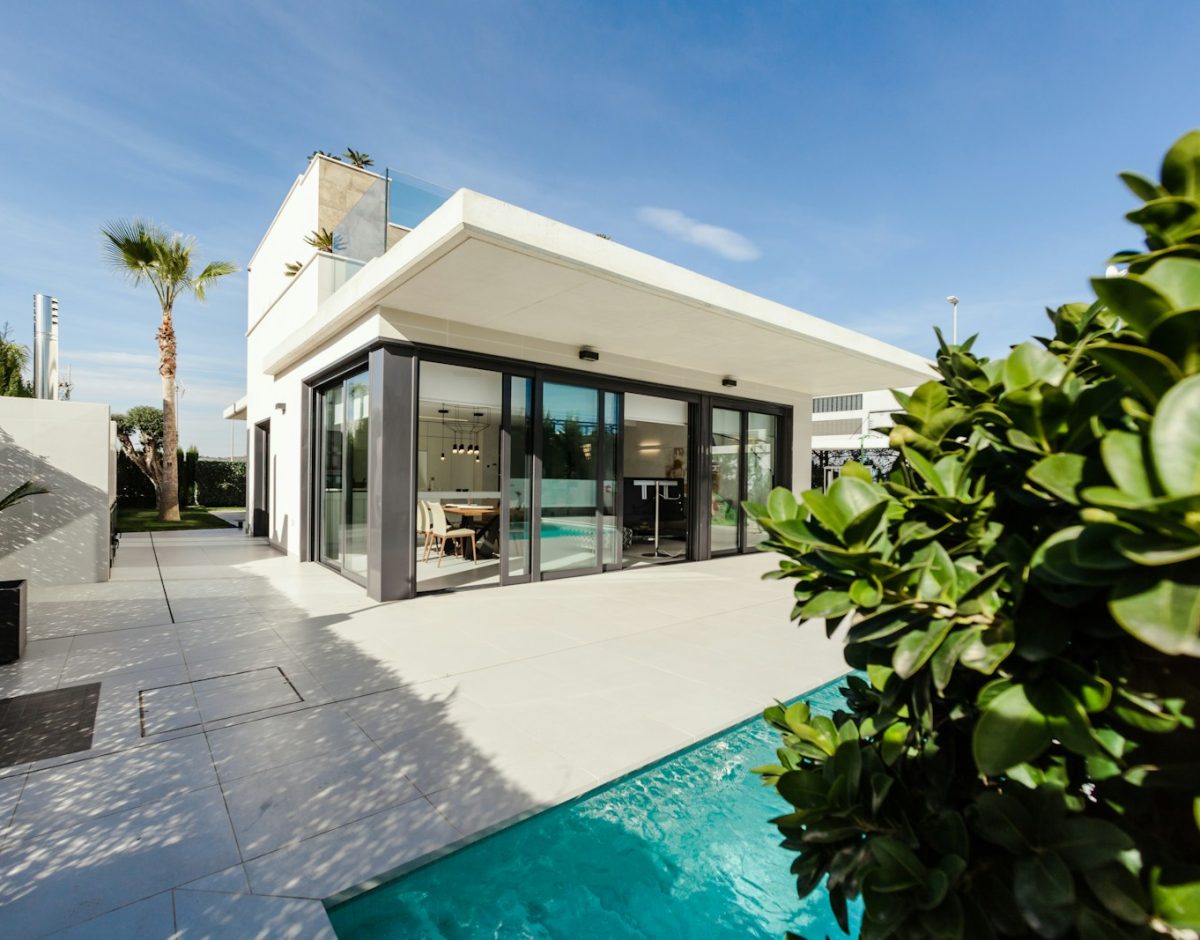 white and grey concrete building near swimming pool under clear sky during daytime